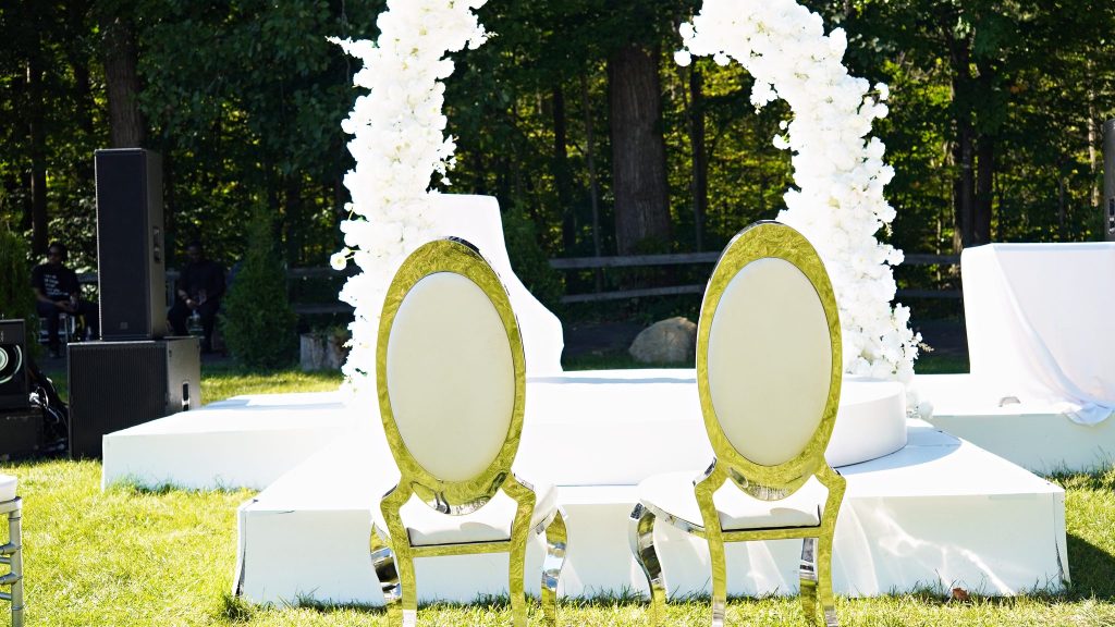 Arche de fleurs blanches et chaises dorées, cérémonie de mariage en plein air à Châteauguay